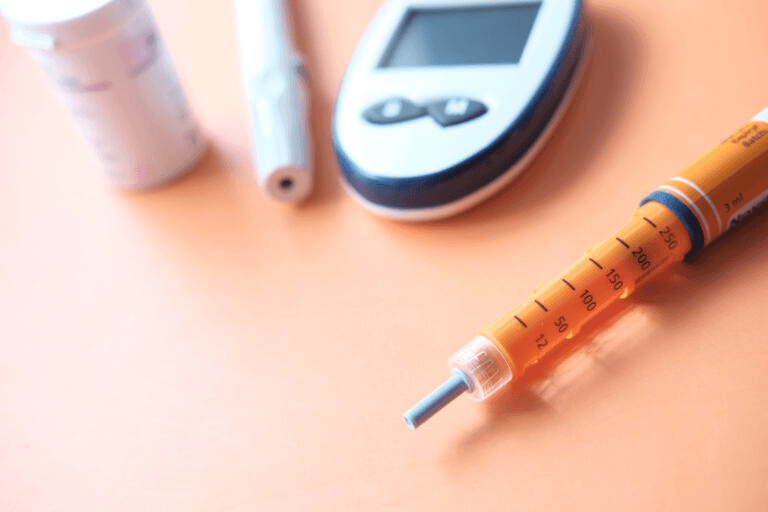 An image of an insulin injection next to a glucose monitor.