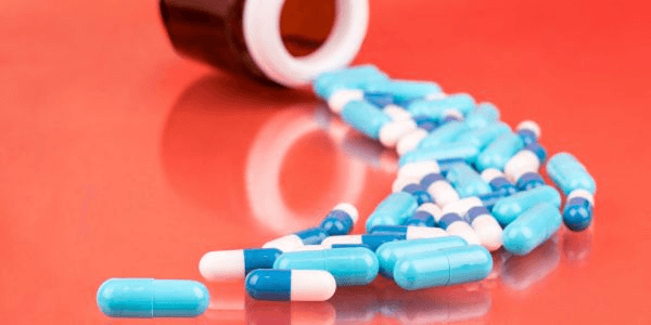 Blue and white capsules representing the idea of Orlistat Weight Loss Pills.