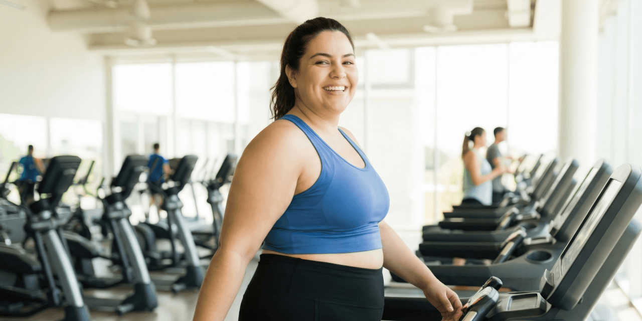 Young woman walking on a treadmill in a modern gym