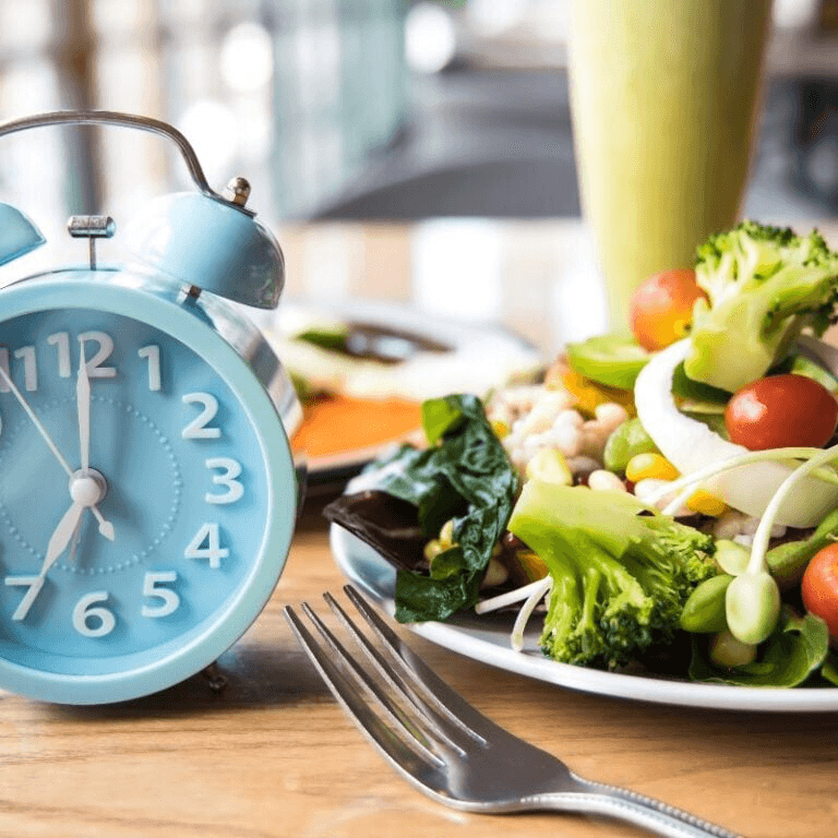 An image of a clock and a plate of food, representing the idea of intermittent fasting.