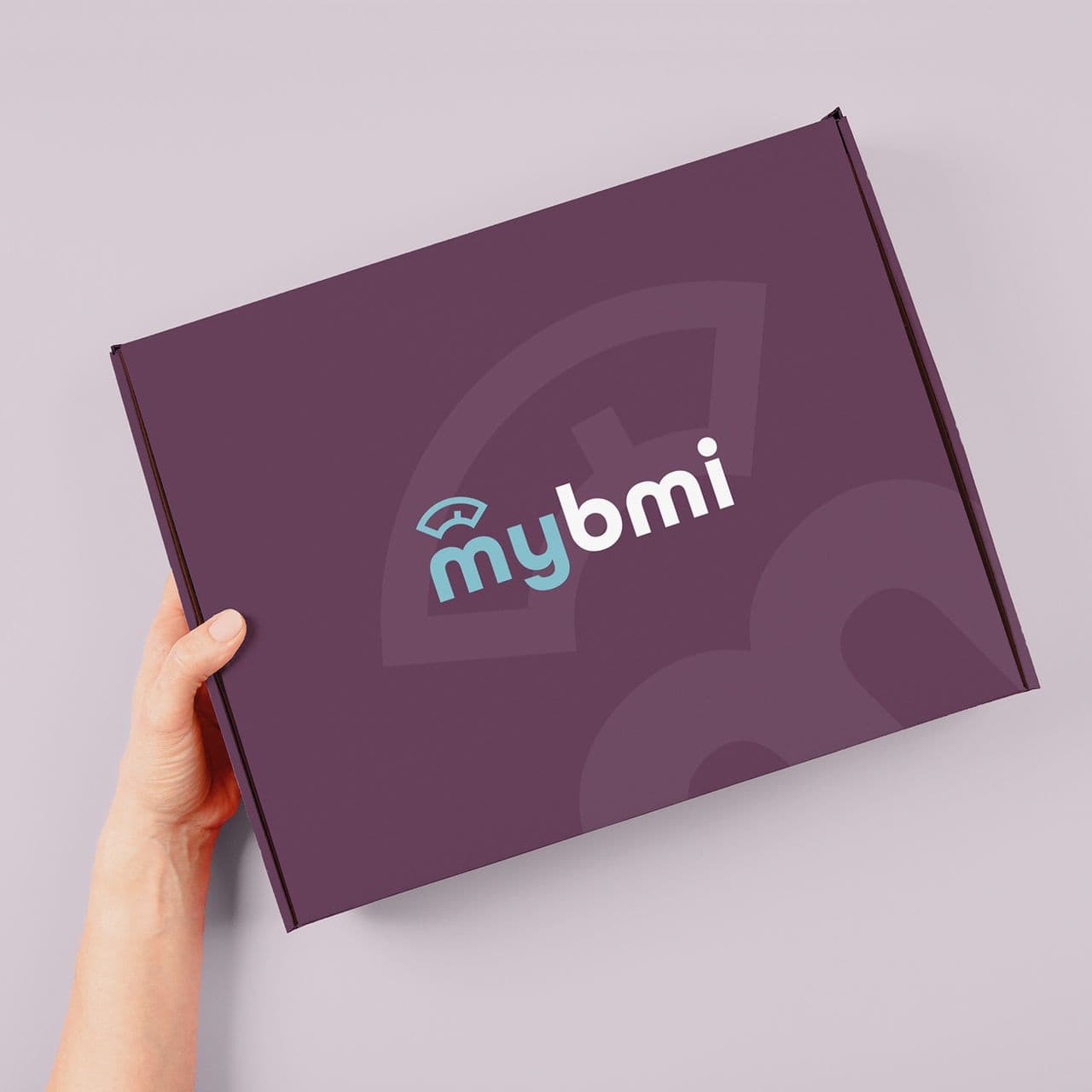 A hand holding a box containing weight loss treatment from myBMI