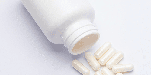 A box of non-descript medicines and a white pill box.