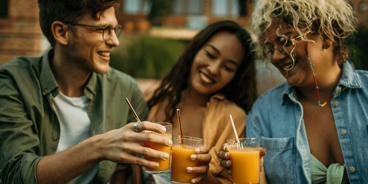 A group of three friends enjoying a drink on a terrace