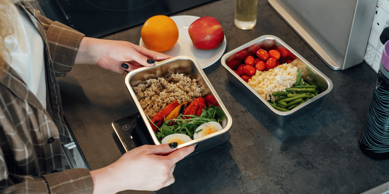 Woman measuring food in a metal tupperware