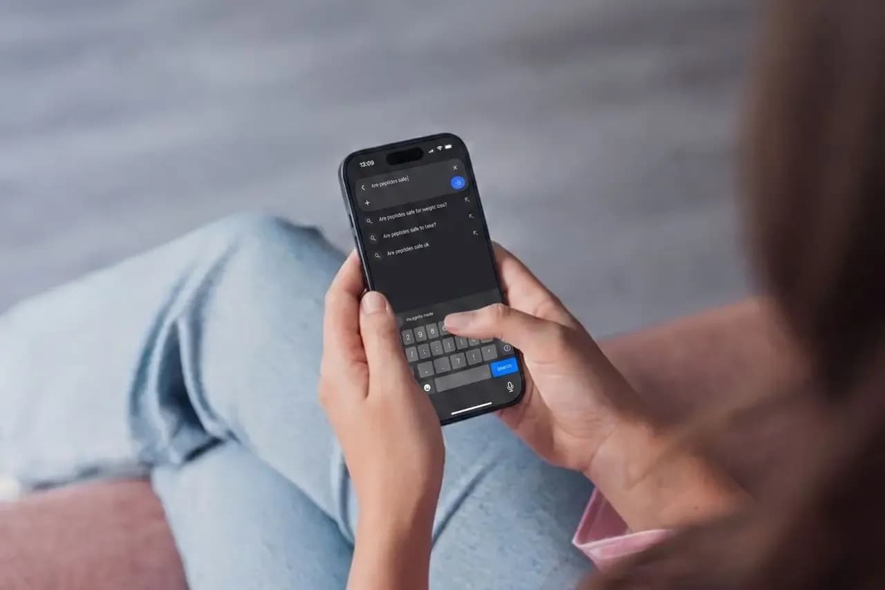 Above view of women's hands as she's using her phone to research peptides.