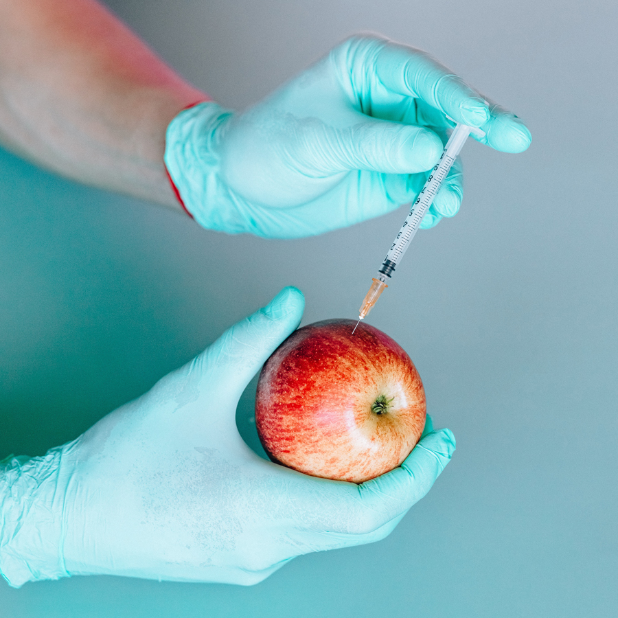 someone injecting an apple
