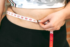 female using tape measure over stomach
