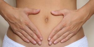 woman holding her hands over her stomach
