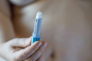 Person holding weight loss injection