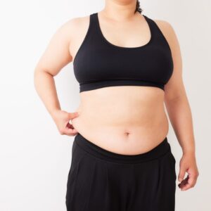a woman holding belly fat, that she is training to lose